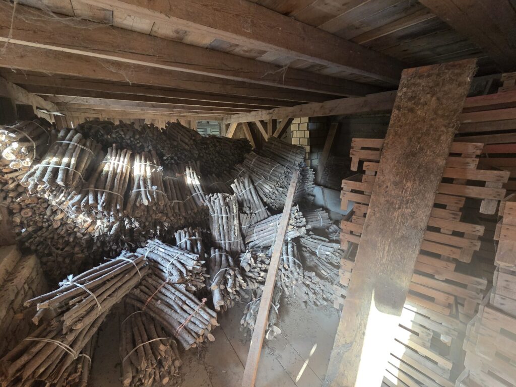 Lagerraum mit gebündelten Holzpfählen und Paletten